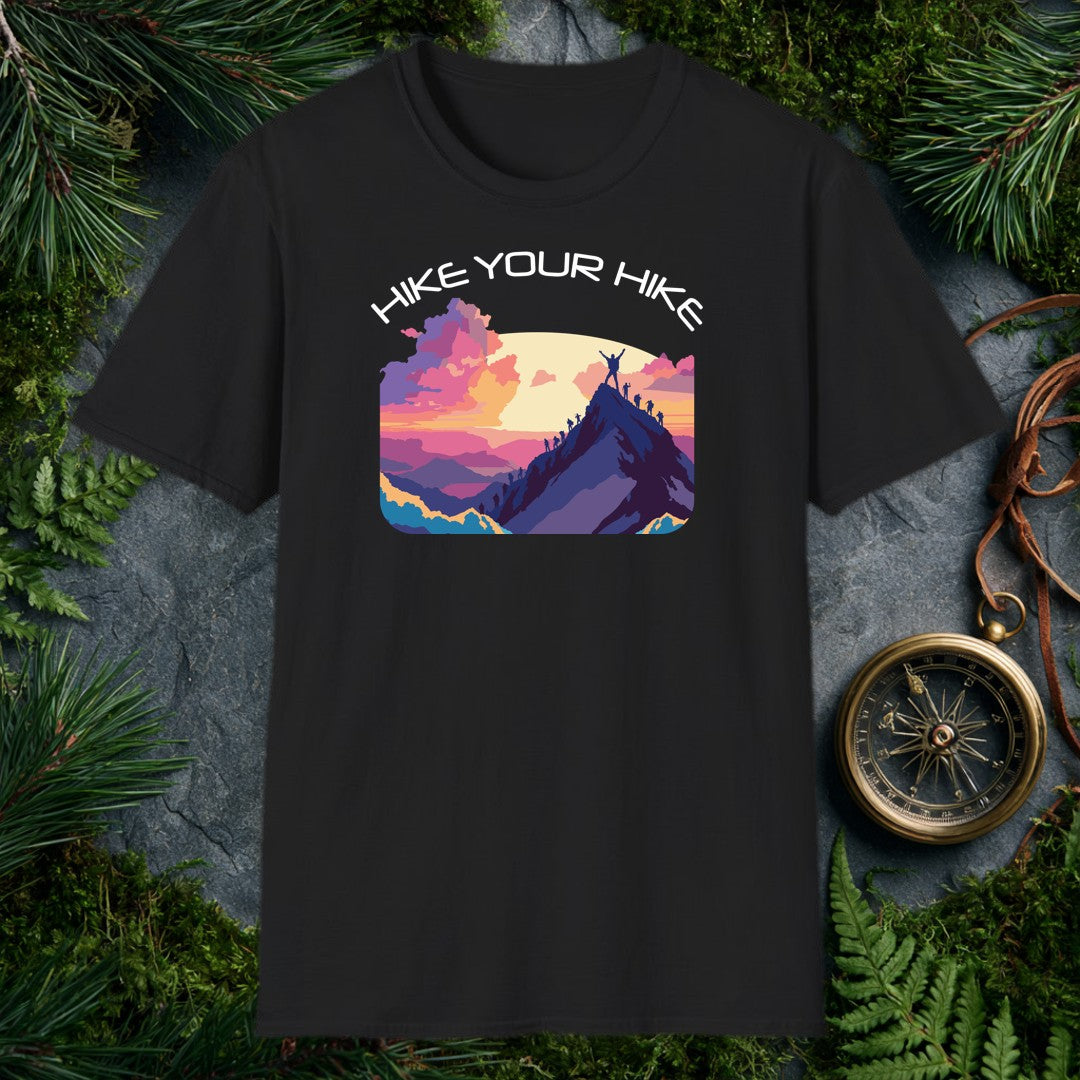 A line of silhouetted hikers winds up a sharp ridge toward the summit, where one climber stands with arms raised against a wide golden sun and a sky of rose…