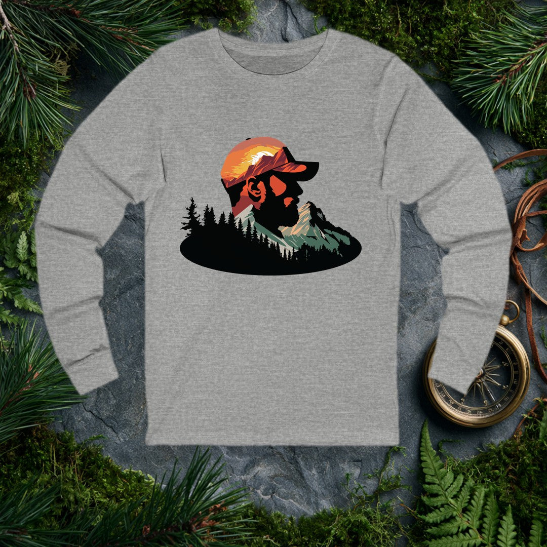 A bearded man in a ball cap becomes the landscape itself — mountains rise through his profile, pines crowd the ridge below, and a warm sunset burns behind the…