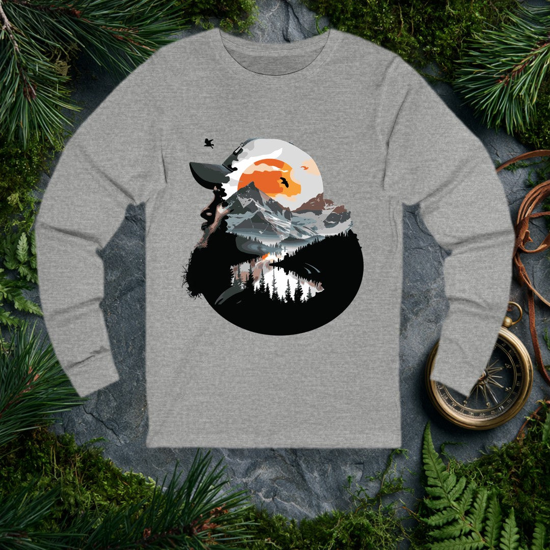 A bearded hiker looks skyward into a double-exposure scene — snow-capped peaks, a mirror-still alpine lake, pine silhouettes, and a rising amber sun with birds…