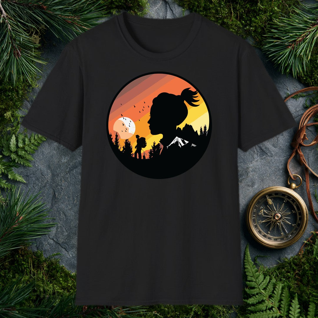 A woman's silhouette faces the horizon while a lone backpacker picks a trail through pine shadows beneath a striped sunset sky — birds lifting off a wide…