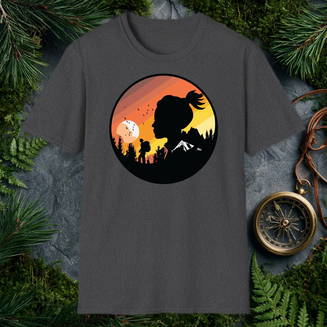 A woman's silhouette faces the horizon while a lone backpacker picks a trail through pine shadows beneath a striped sunset sky — birds lifting off a wide…