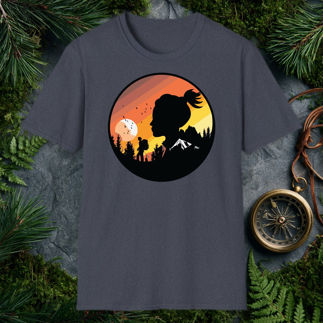 A woman's silhouette faces the horizon while a lone backpacker picks a trail through pine shadows beneath a striped sunset sky — birds lifting off a wide…