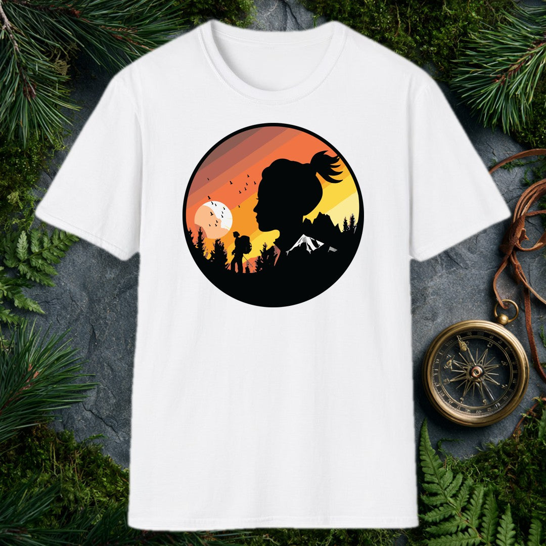 A woman's silhouette faces the horizon while a lone backpacker picks a trail through pine shadows beneath a striped sunset sky — birds lifting off a wide…