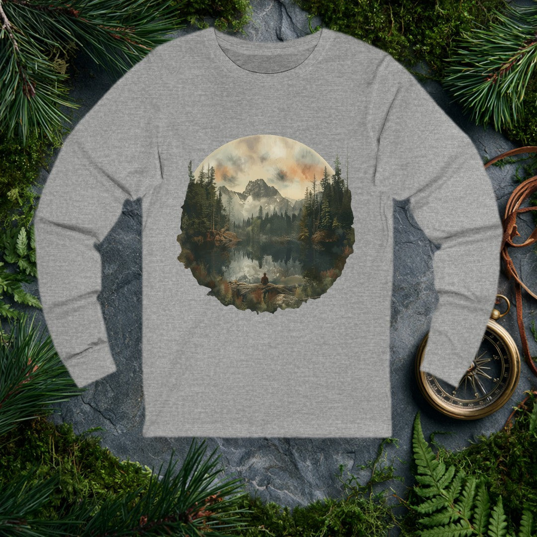 A lone figure sits on a fallen log at the edge of a still alpine lake, watching jagged snow-capped peaks and a stand of dark pines mirror themselves perfectly…