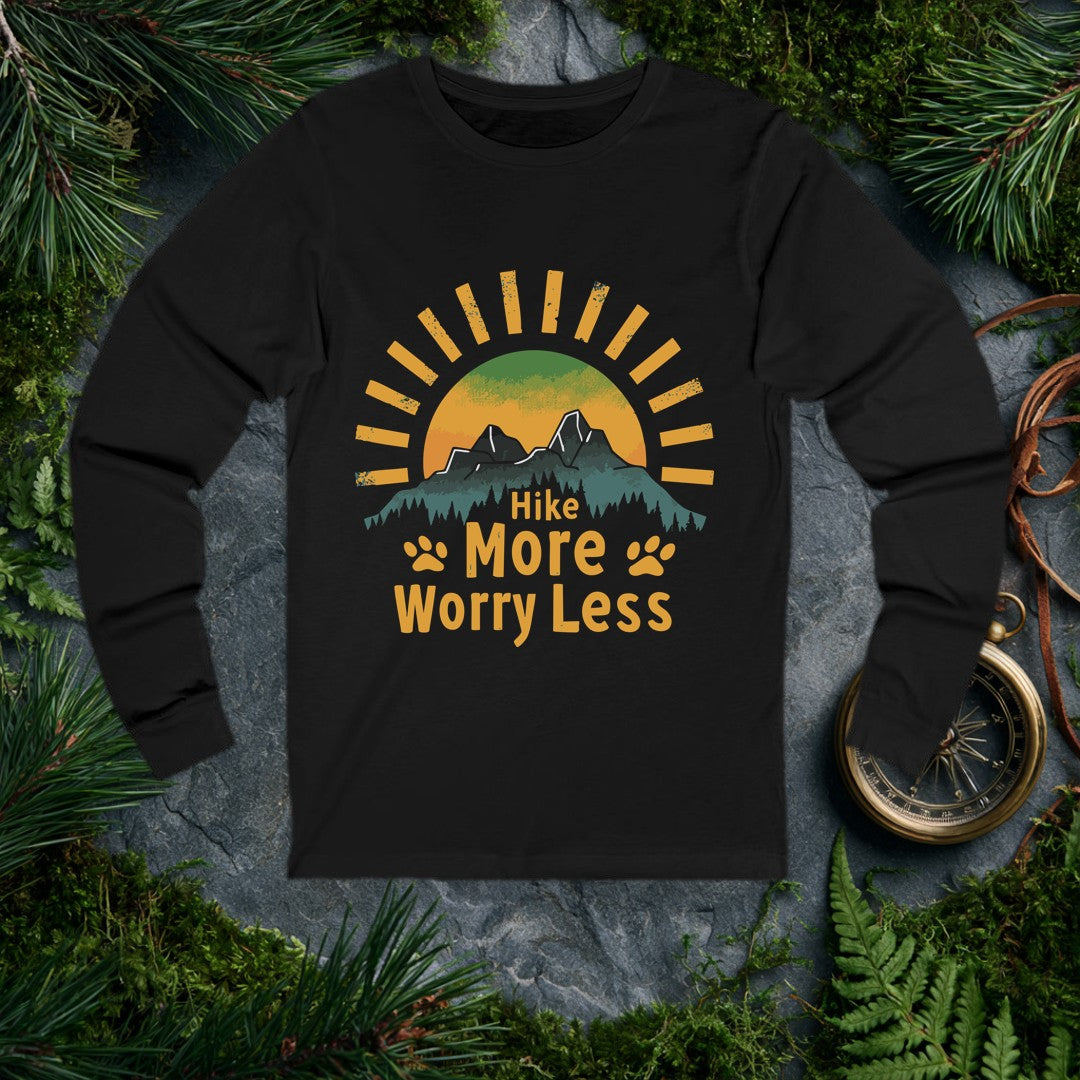 A half-sun rises behind two jagged mountain peaks and a ridge of dark pines, with paw prints flanking the words Hike More Worry Less — for the hiker who brings…