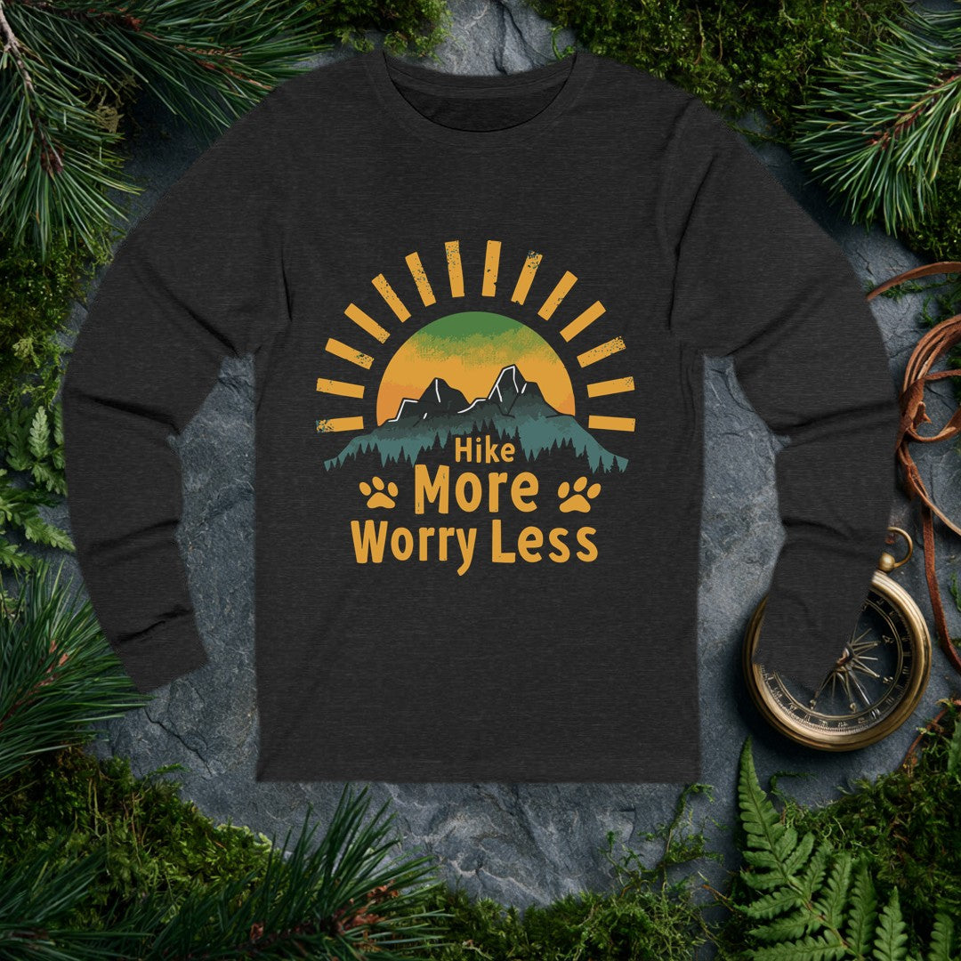 A half-sun rises behind two jagged mountain peaks and a ridge of dark pines, with paw prints flanking the words Hike More Worry Less — for the hiker who brings…