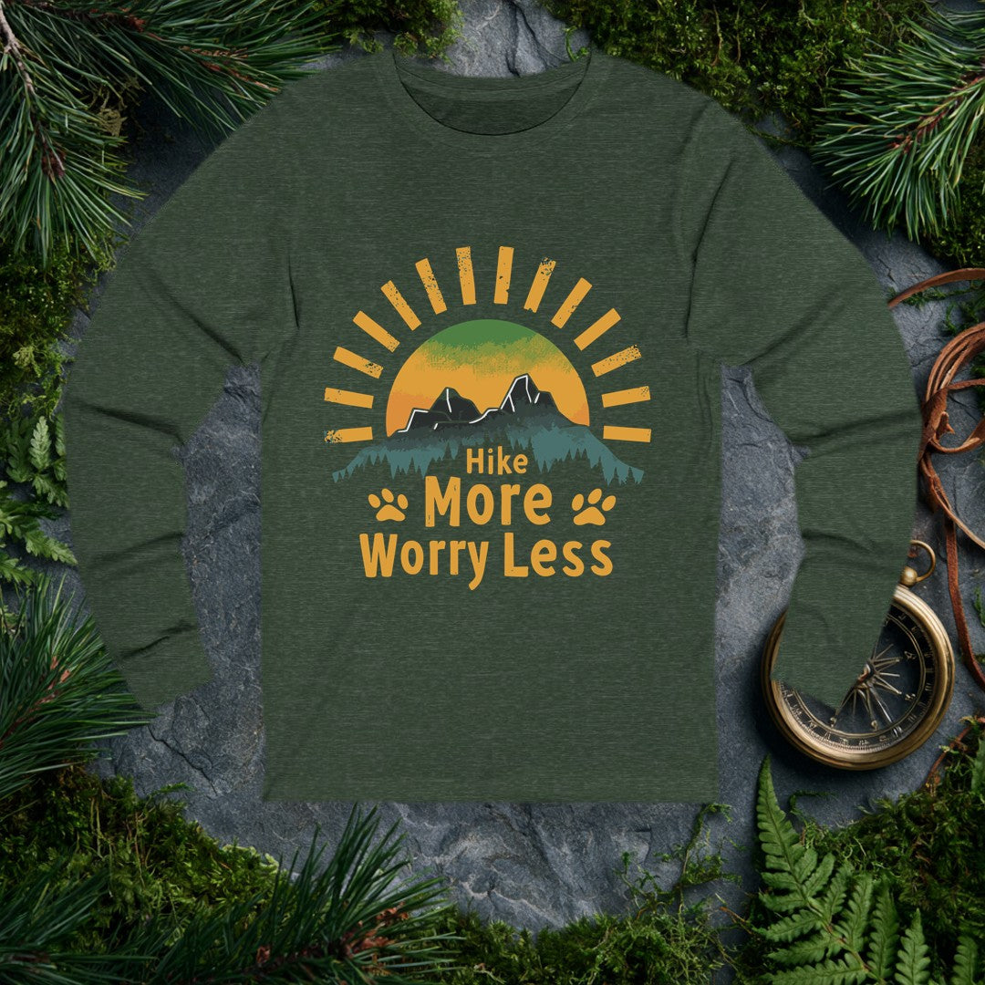 A half-sun rises behind two jagged mountain peaks and a ridge of dark pines, with paw prints flanking the words Hike More Worry Less — for the hiker who brings…