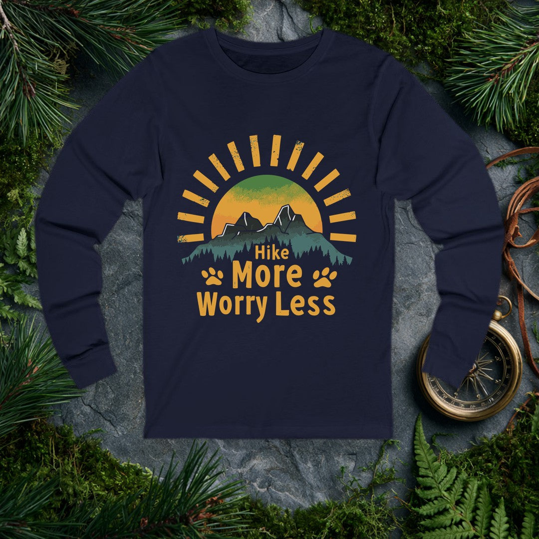 A half-sun rises behind two jagged mountain peaks and a ridge of dark pines, with paw prints flanking the words Hike More Worry Less — for the hiker who brings…