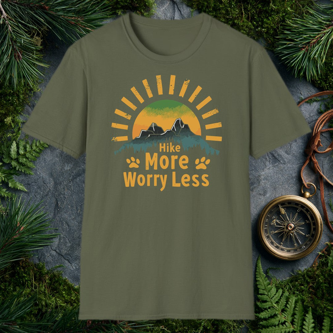 A half-sun rises behind two jagged mountain peaks and a ridge of dark pines, with paw prints flanking the words Hike More Worry Less — for the hiker who brings…