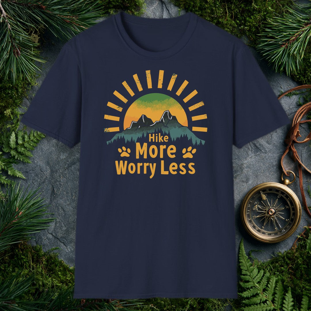 A half-sun rises behind two jagged mountain peaks and a ridge of dark pines, with paw prints flanking the words Hike More Worry Less — for the hiker who brings…