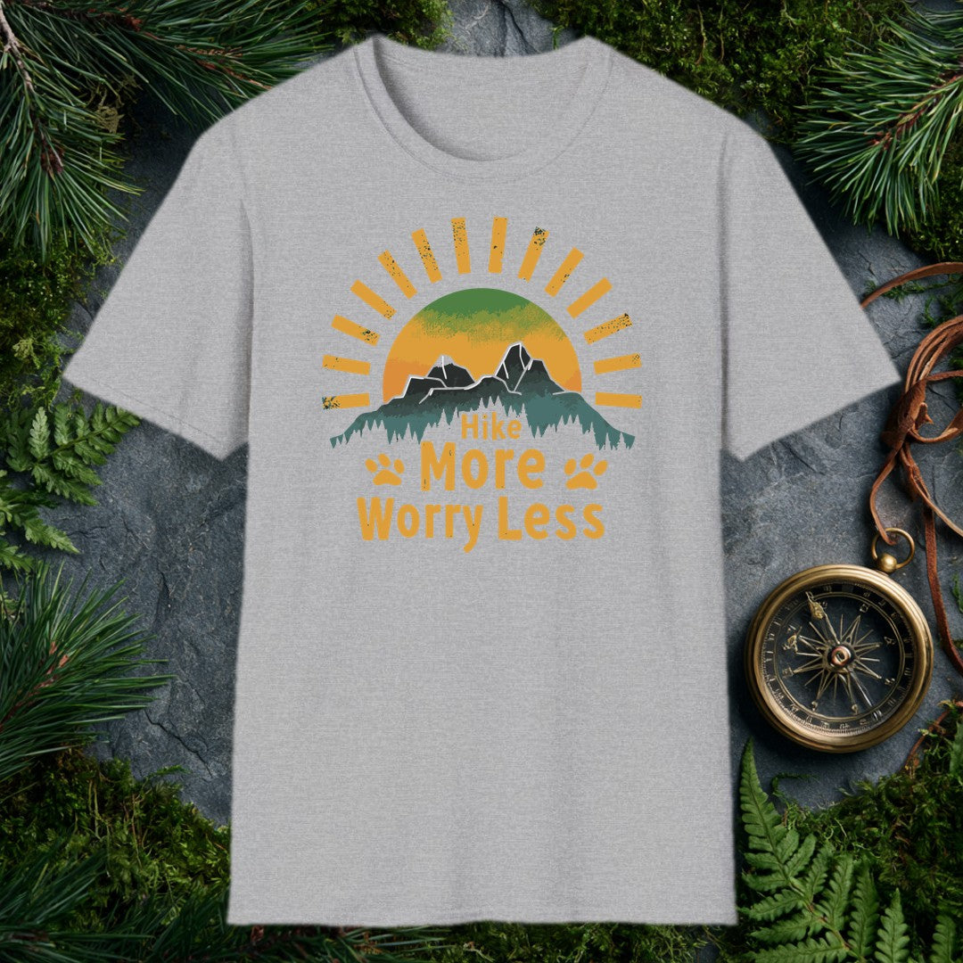 A half-sun rises behind two jagged mountain peaks and a ridge of dark pines, with paw prints flanking the words Hike More Worry Less — for the hiker who brings…