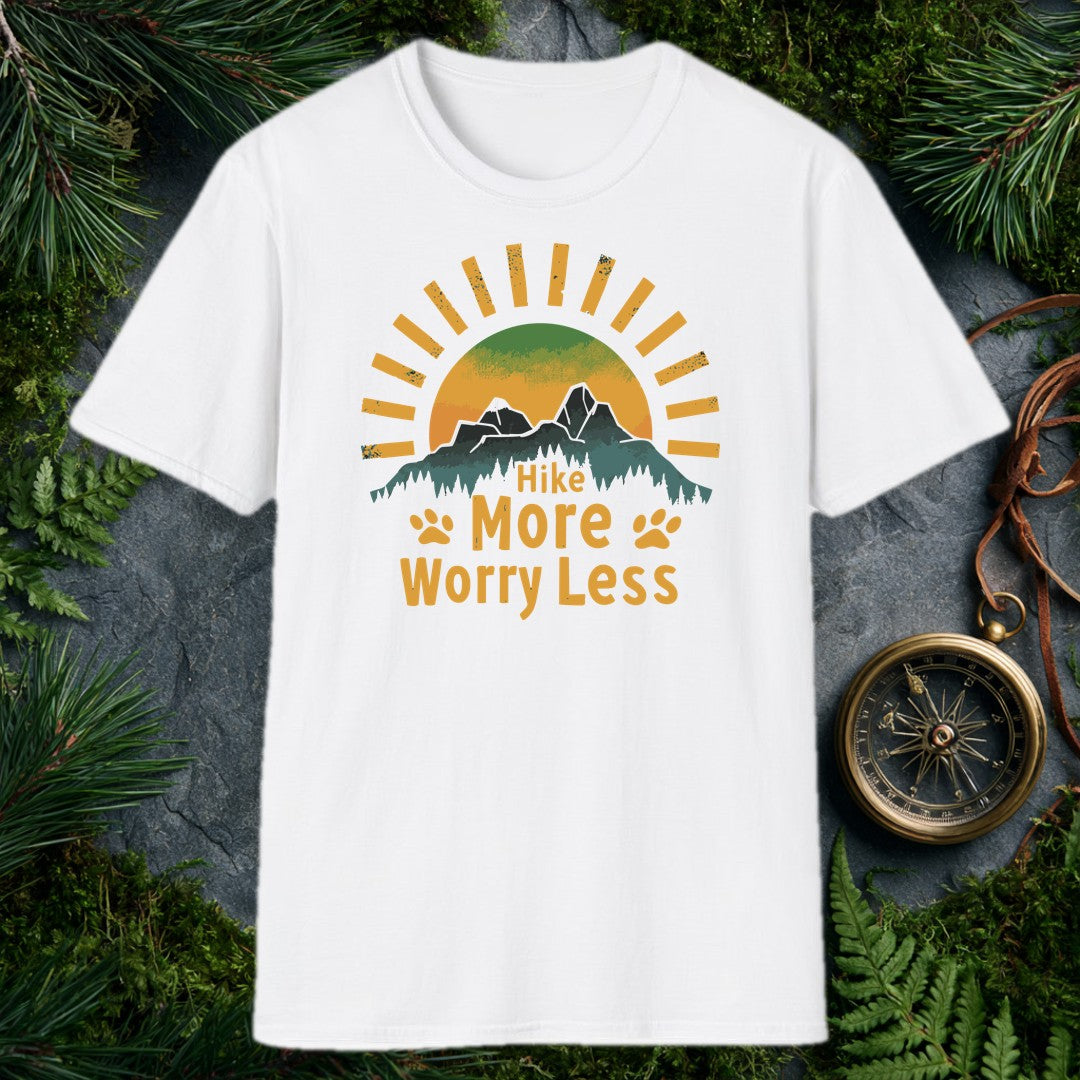 A half-sun rises behind two jagged mountain peaks and a ridge of dark pines, with paw prints flanking the words Hike More Worry Less — for the hiker who brings…