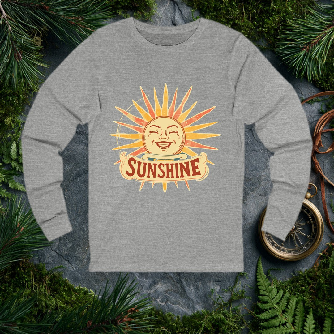 A grinning retro sun — rosy cheeks, laughing eyes, rays blazing in amber and coral — beams above a hand-lettered banner that reads Sunshine . For the optimist…