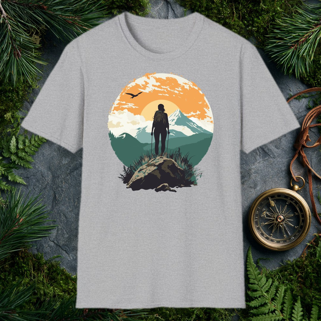 silhouette of female hiker with trekking poles on rocky summit, snow-capped mountain and orange sunrise behind her, bird