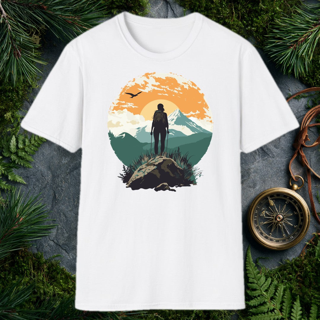 silhouette of female hiker with trekking poles on rocky summit, snow-capped mountain and orange sunrise behind her, bird
