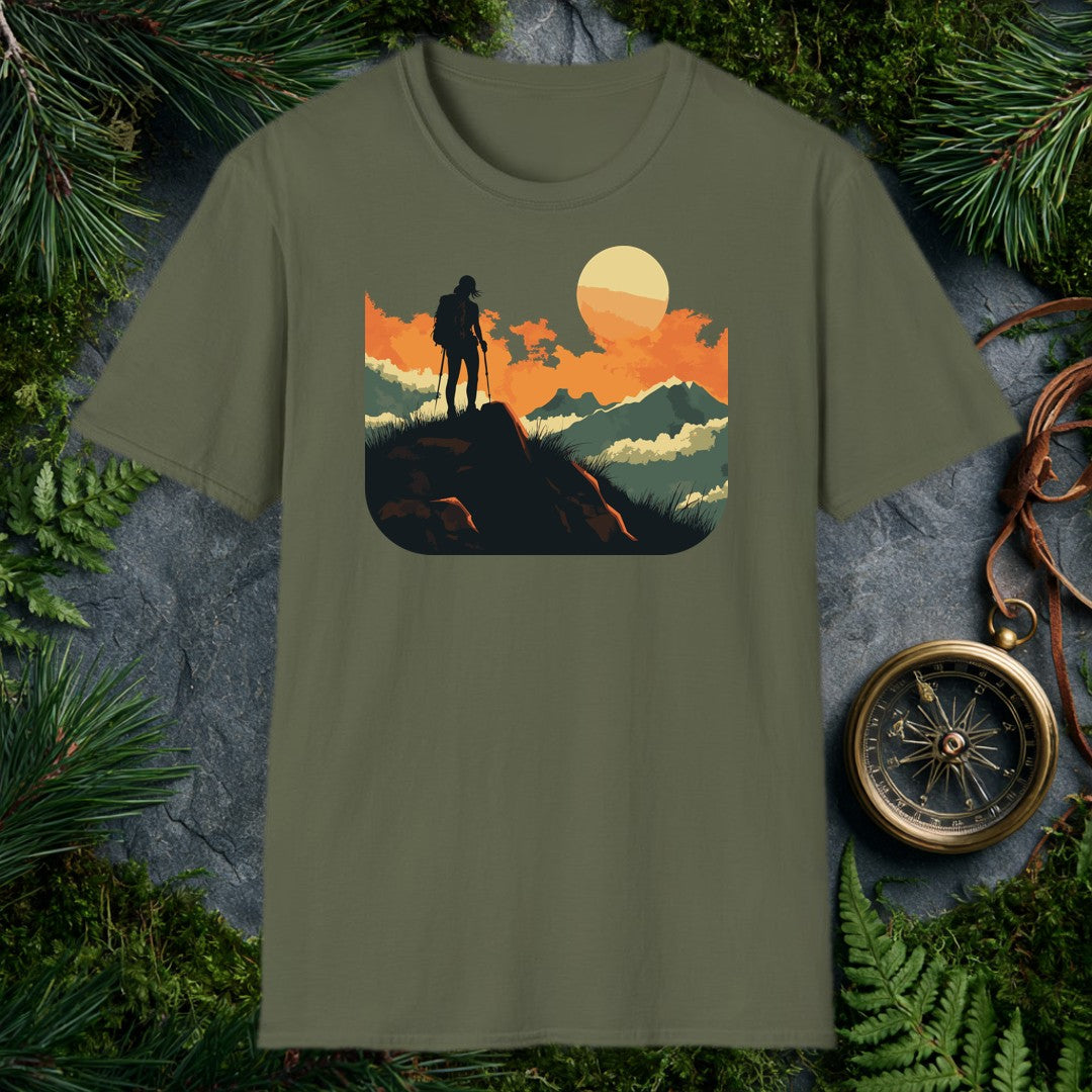 silhouette of a female hiker with backpack and trekking poles standing on a rock at sunset with layered mountains behind