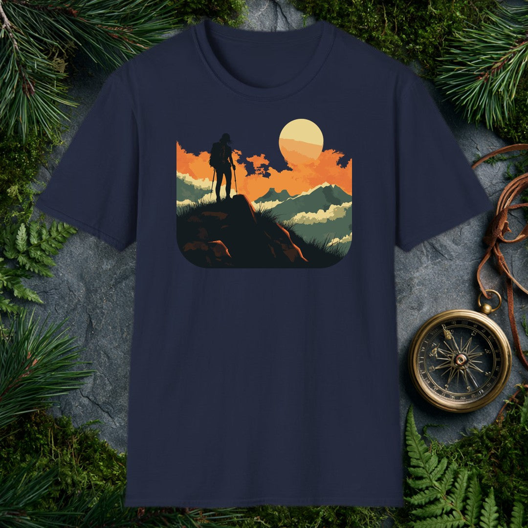 silhouette of a female hiker with backpack and trekking poles standing on a rock at sunset with layered mountains behind