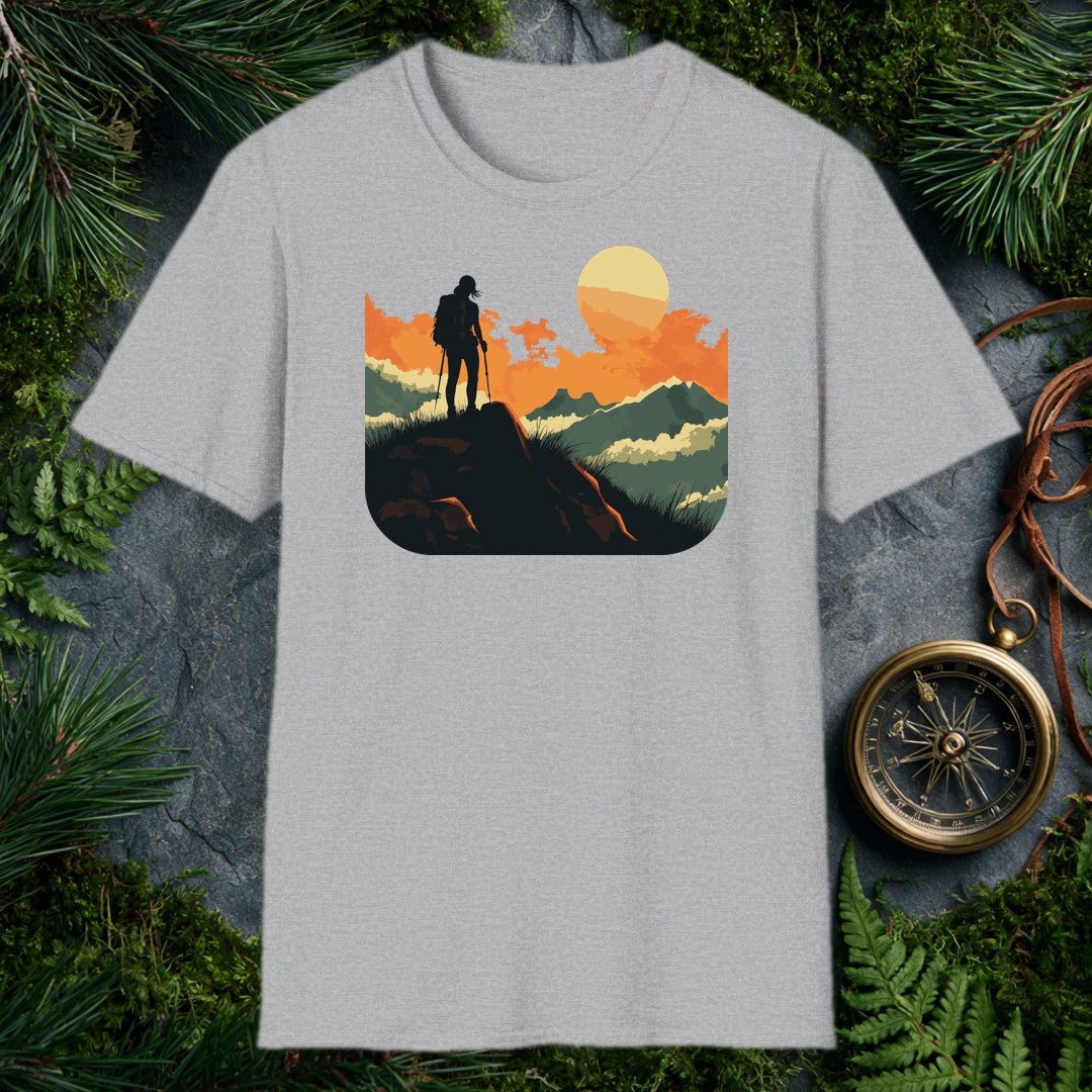 silhouette of a female hiker with backpack and trekking poles standing on a rock at sunset with layered mountains behind