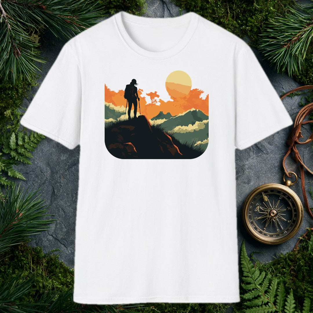 silhouette of a female hiker with backpack and trekking poles standing on a rock at sunset with layered mountains behind